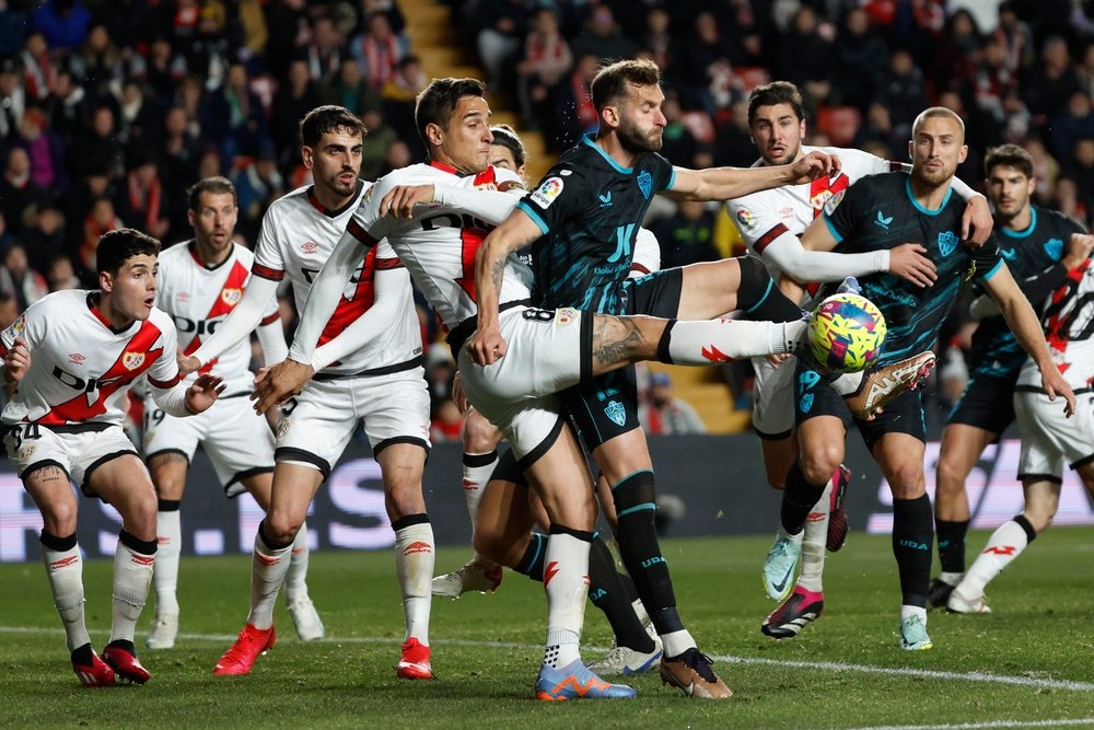 El delantero argentino del Rayo Vallecano Óscar Trejo disputa el balón ante el jugador brasileño del Almeria Leo Baptistao durante el encuentro correspondiente a la jornada 20 de primera división de este lunes en el estadio de Vallecas, en Madrid. EFE / Juanjo Martín.