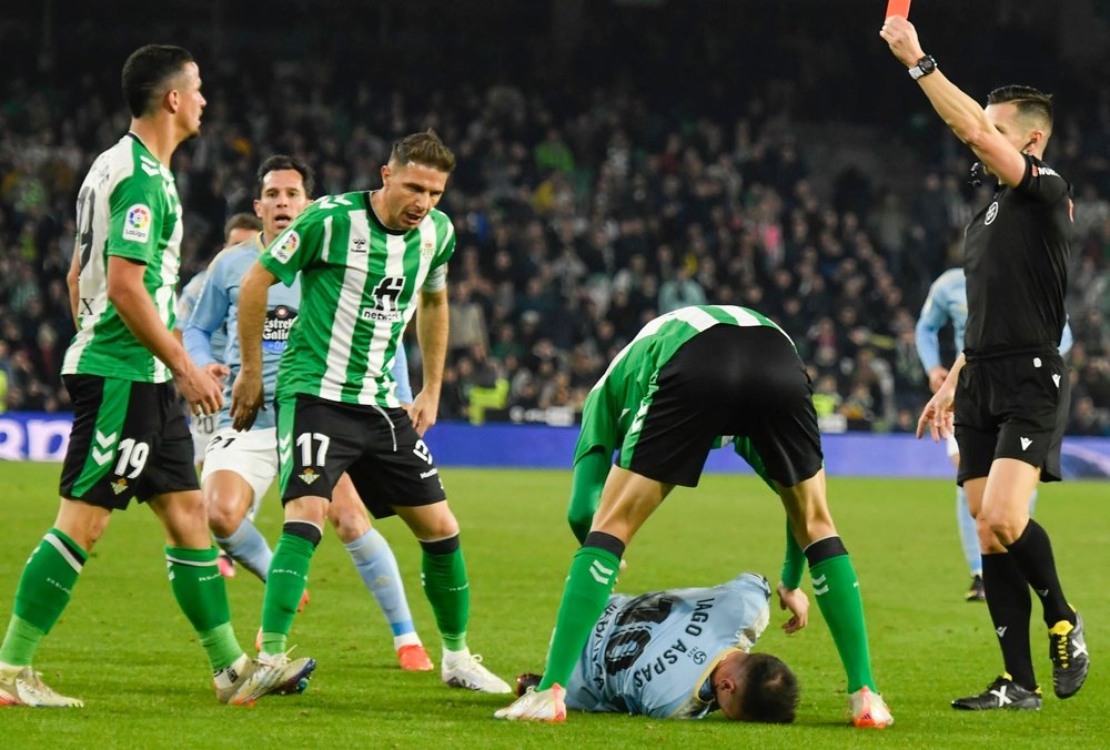 Momento en el que el árbitro Carlos del Cerro Grande saca tarjeta roja directa a Luiz Felipe (i), del Real Betis, por su acción sobre Iago Aspas, del Celta de Vigo, durante el partido de la jornada 20 de la Liga Santander disputado en el estadio Benito Villamarín, en Sevilla. EFE/ Raúl Caro.