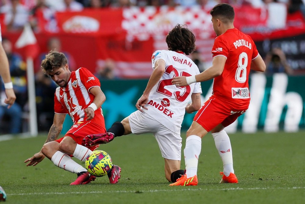 El delantero del Sevilla Bryan Gil (c) y los jugadores del Almería, Alex Pozo (i) y Portillo (d), durante el partido de Liga disputado entre Sevilla FC y UD Almería, este domingo en el estadio Sánchez Pizjuan de Sevilla. EFE/José Manuel Vidal