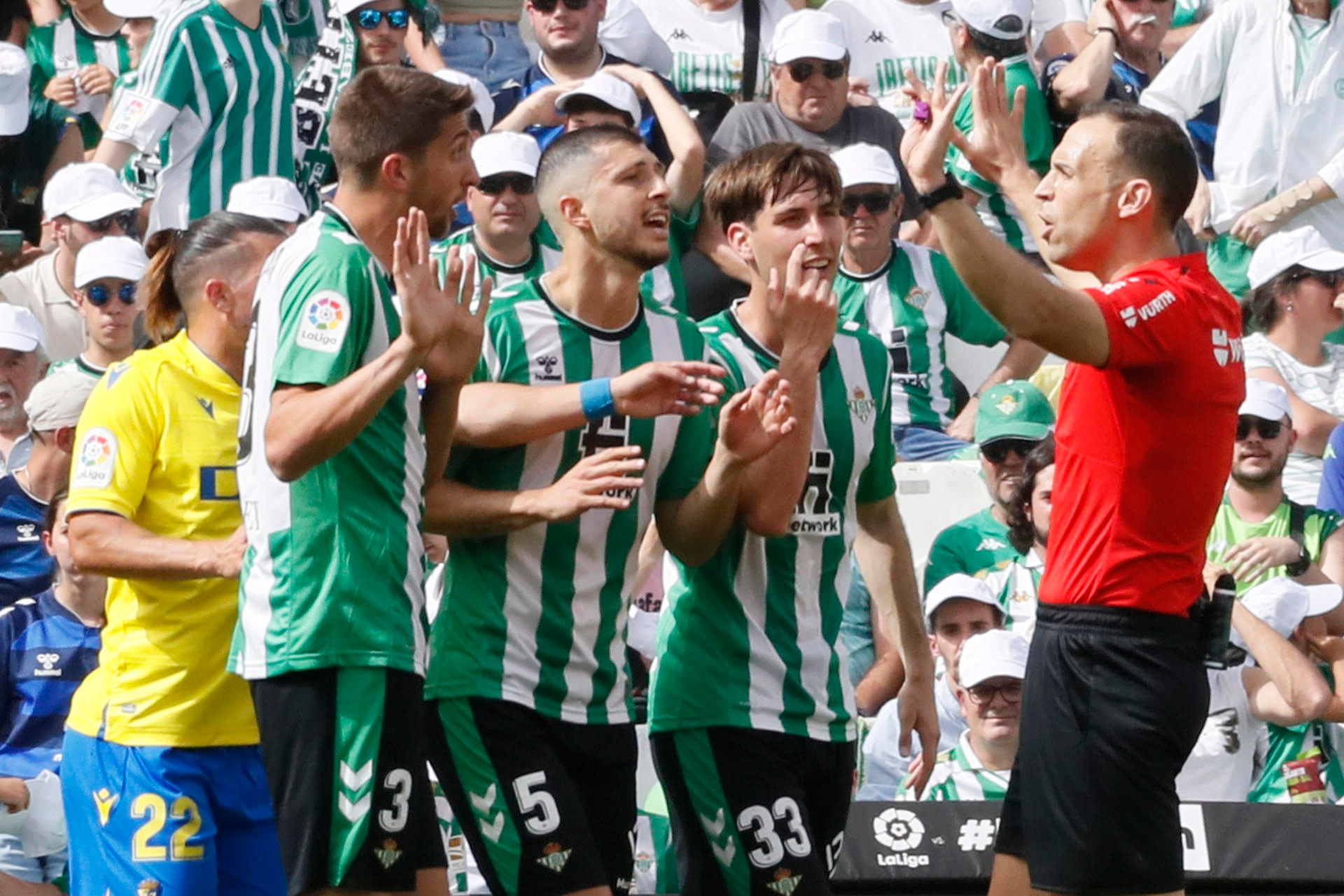 Los jugadores del Betis discuten con el árbitro Cuadra Fernández (d) tras la expulsión de Canales en el estadio Benito Villamarín de Sevilla. EFE/José Manuel Vidal