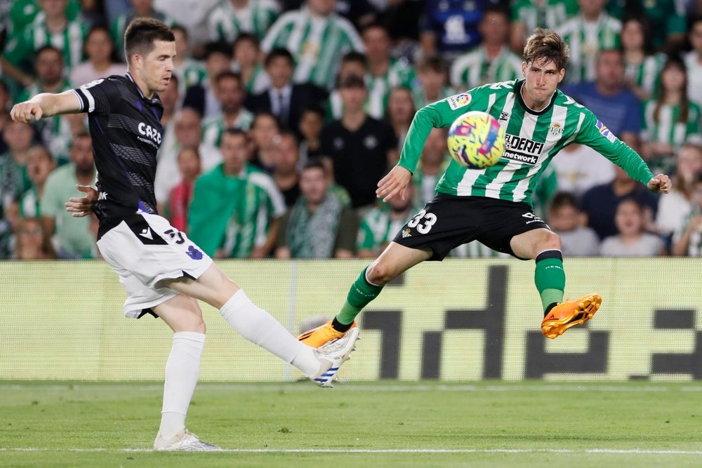 El centrocampista de la Real Sociedad, Igor Zubeldia (i), golpea el balón ante el defensa del Betis, Juan Miranda, durante el encuentro correspondiente a la jornada 31 de primera división disputado en el estadio Benito Villamarín, en Sevilla. EFE/José Manuel Vidal.