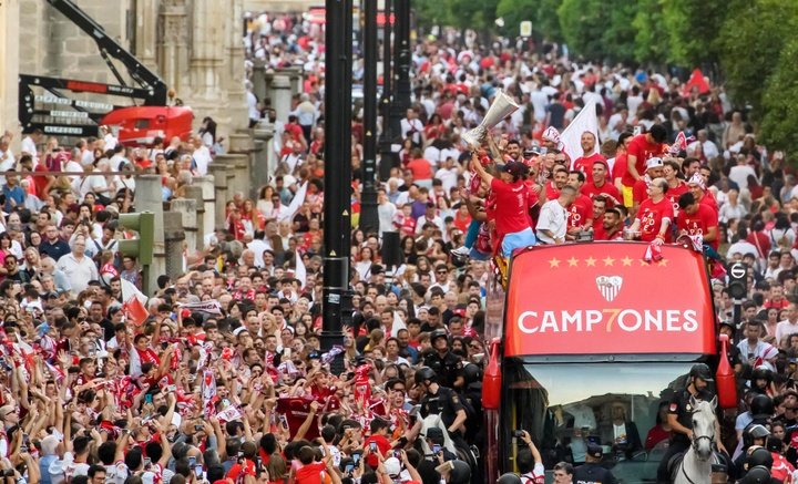Los jugadores del Sevilla FC, junto a los directivos y cuerpo técnico, celebran la copa de la Liga Europa, séptima del equipo hispalense, cosechada en la final ante la Roma, en la fuente Puerta de Jerez de Sevilla. EFE/ Raúl Caro