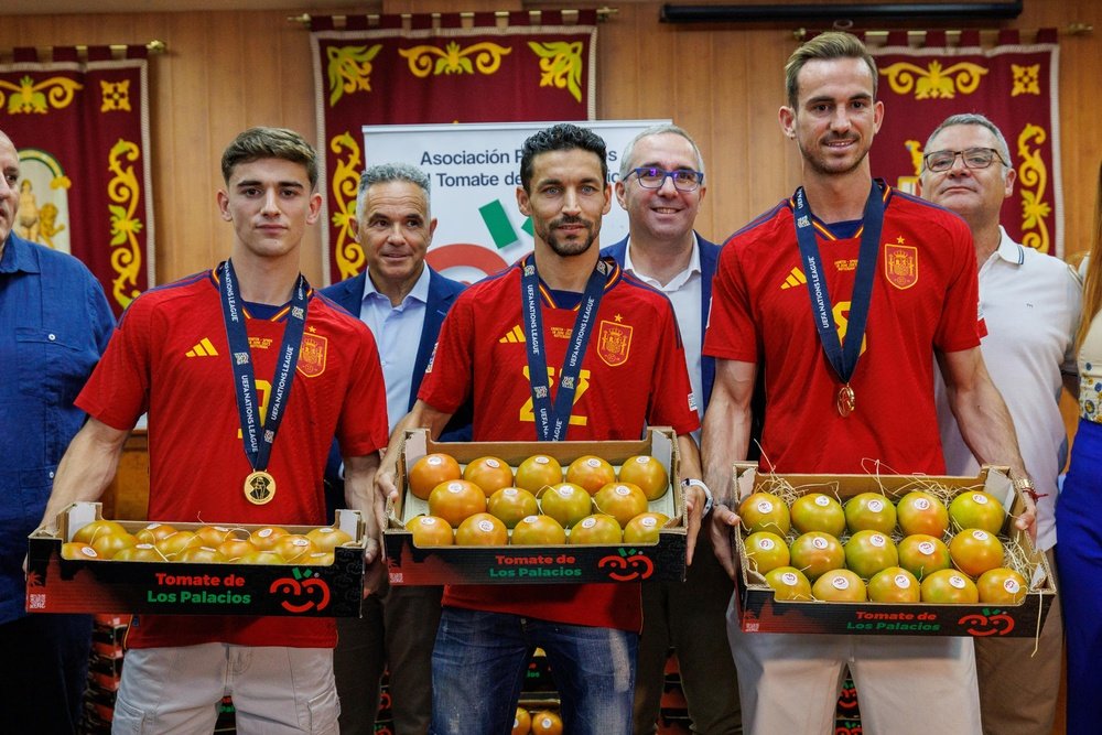 Los futbolistas Jesús Navas (c), Fabián Ruiz (d) y Pablo Páez Gavira `Gavi` (i) reciben su peso en tomates durante el homenaje que su pueblo, Los Palacios y Villafranca (Sevilla), les concede tras la consecución del título de la Liga de Naciones ante Croacia, en un encuentro en el que los tres palaciegos fueron titulares en el once del seleccionador Luis de la Fuente. EFE/ Julio Muñoz