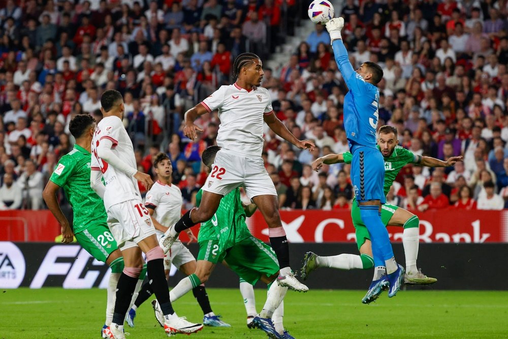 El defensa francés del Sevilla Loïc Badé (cd), no puede rematar ante Vieites (d), portero del Real Betis, durante el partido de la Jornada 13 de LaLiga que estos dos equipos jugaron en el estadio Sánchez Pizjuán. EFE/Julio Muñoz