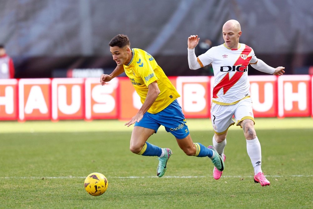 El defensa de Las Palmas, Sergi Cardona (i) lucha por el balón con el centrocampista Isi Palazón (d) del Rayo Vallecano durante el partido correspondiente a la jornada 21ª disputado en Vallecas. EFE/ Rodrigo Jiménez