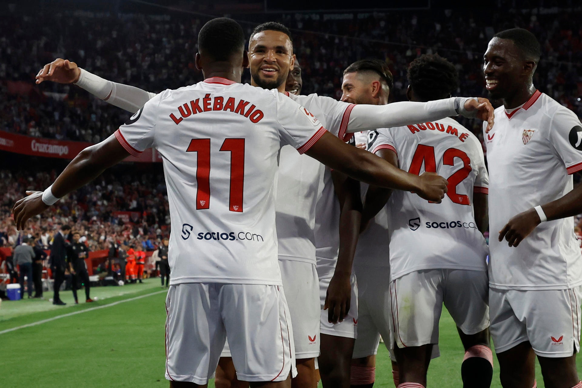 El delantero belga del Sevilla FC Dodi Lukébakio (i) celebra con su compañeros tras marcar el 3-0 ante el Granada durante el partido de la Jornada 34 de LaLiga jugaron en el estadio Sánchez Pizjuán. EFE/ Julio Muñoz