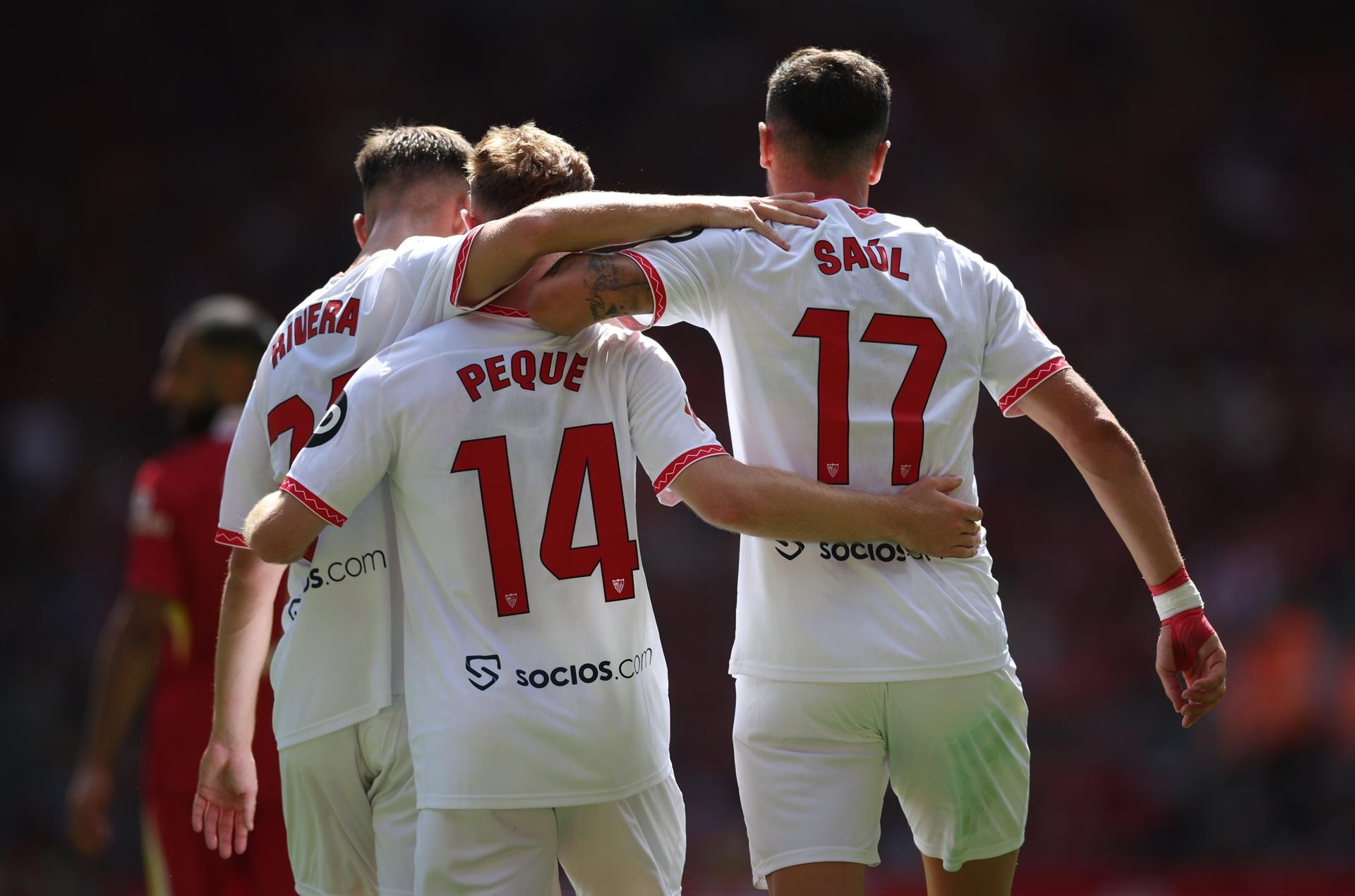 Peque Fernandez (C) del Sevilla celebra el 3-1, junto a Pablo Rivera (i) y Saul Ñiguez (d), durante el amistoso jugado ante el Liverpool, en terreno inglés. (Futbol, Amistoso, Reino Unido) EFE/EPA/ADAM VAUGHAN