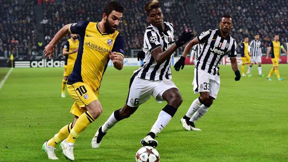 Arda Turan, disputando un balón con Paul Pogba en un Atlético-Juventus