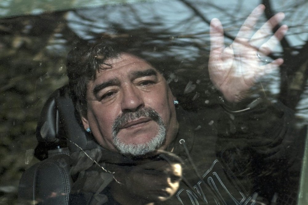 Argentina former football star Diego Armando Maradona waves to supporters as he leaves the funeral of his father Don Diego, in Bella Vista, outskirts of Buenos Aires, on June 26, 2015