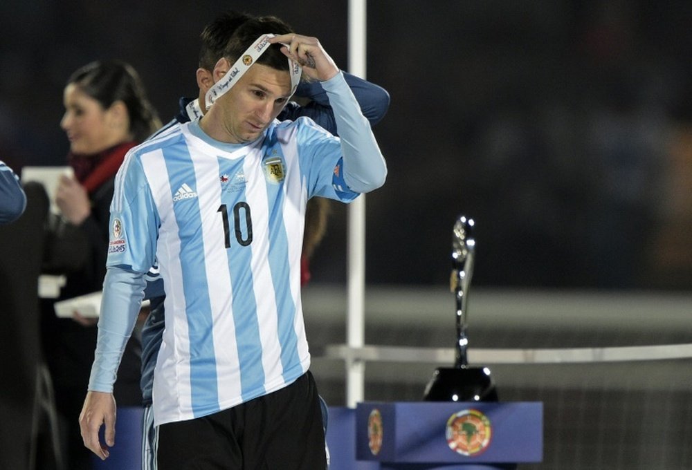Argentina forward Lionel Messi takes off the second place medal of the 2015 Copa America football championship, in Santiago, Chile, on July 4, 2015