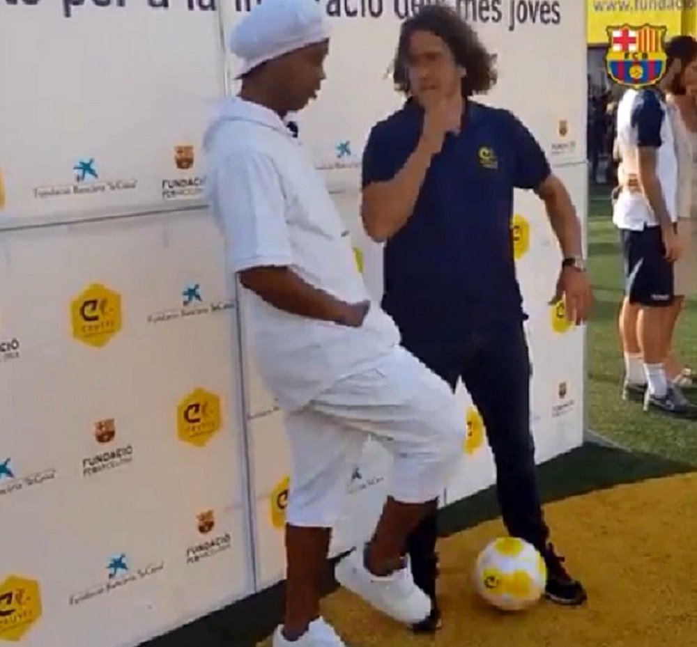 Ronaldinho le hizo un caño a Puyol. Captura/FCBarcelona_es