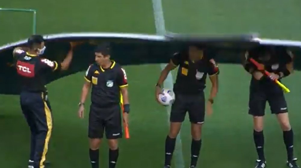 Los árbitros posaron para la foto... ¡y les cayó encima la cartelería! Twitter/BrasileiraoPlay
