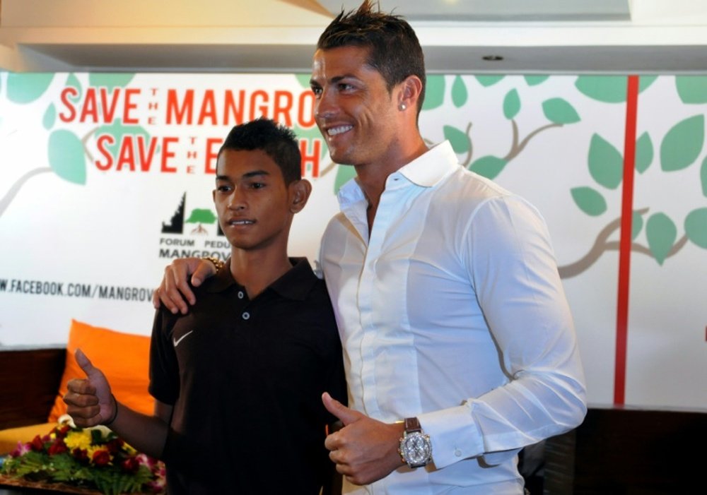 Christiano Ronaldo (R) is reunited with Martunis, an Indonesian survivor of the deadly 2004 Aceh tsunami who the Real Madrid star met in 2005 during a mission to assist tsunami victims, in Kuta on June 26, 2013