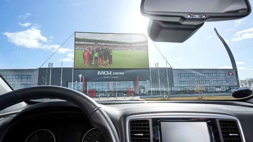 Un autocine en el aparcamiento para ver el fútbol. Midtjylland
