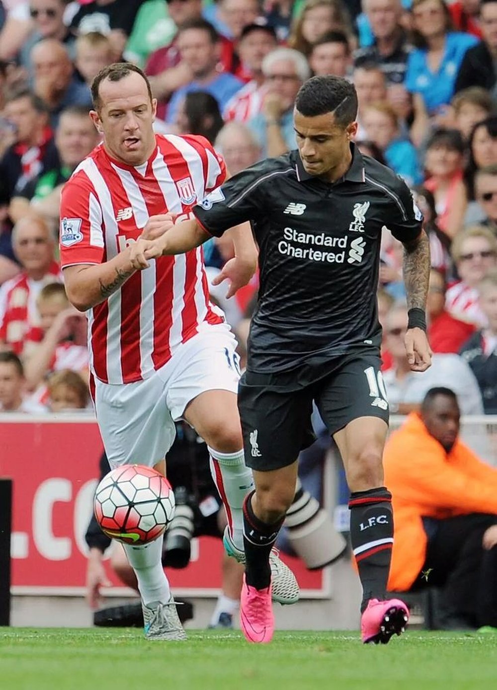 Coutinho conduce un balón perseguido por Charlie Adam. LiverpoolFC