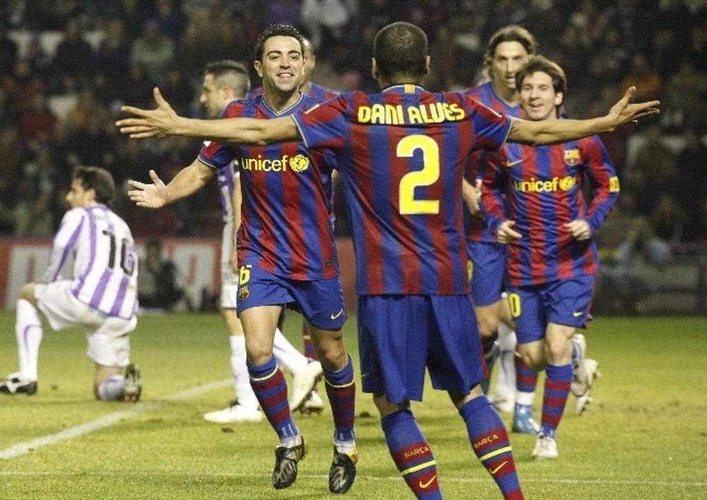 Dani Alves et Xavi Hernandez lors d'un match avec le FC Barcelone. AFP