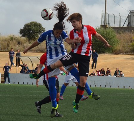 Dos futbolistas, del Cajasol Sporting de Huelva y el Athletic Club Femenino, pelean por un balón elevado. SportingClubHuelva