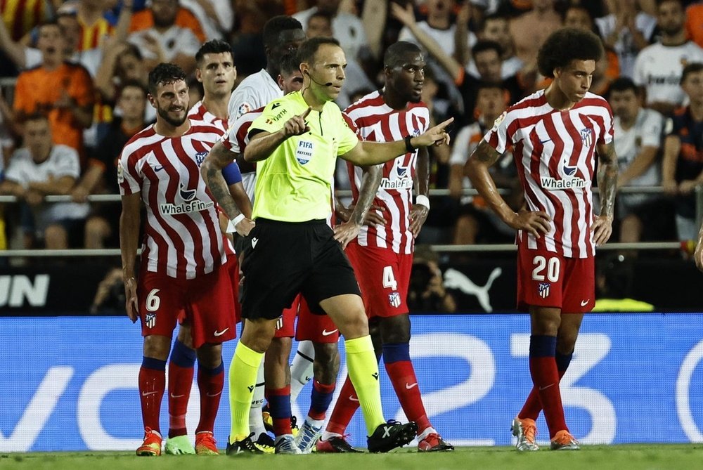 El árbitro Cuadra Fernández (c) se dirige al monitor del VAR, durante el partido de la tercera jornada de Liga en Primera División que Valencia CF y Atlético de Madrid disputan en el estadio de Mestalla. EFE/Biel Aliño