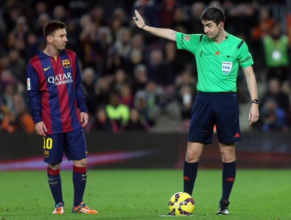 El árbitro español, Undiano Mallenco (d), en un partido arbitrado al Barcelona la pasada campaña, junto a Leo Messi. Twitter