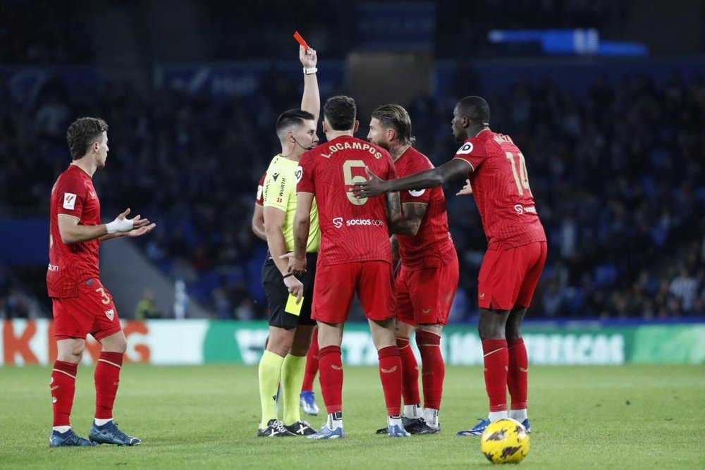 El defensa del Sevilla FC Sergio Ramos (2d) recibe una tarjeta roja durante el partido de la jornada 14 de LaLiga que Real Sociedad y Sevilla disputan en el Reale Arena de San Sebastián. EFE/JuanHerrero