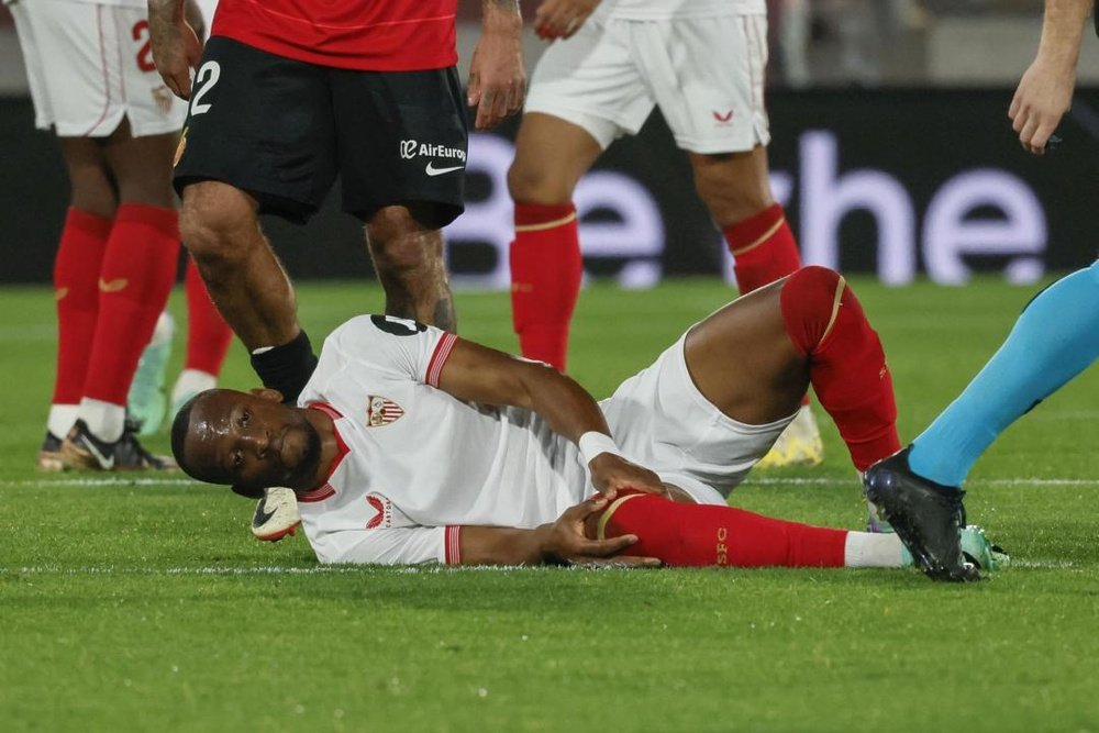 El delantero congoleño del Sevilla, Dodi Lukebakio, se duele en el terreno de juego tras caer lesionado ante el Mallorca. EFE/CATICLADERA
