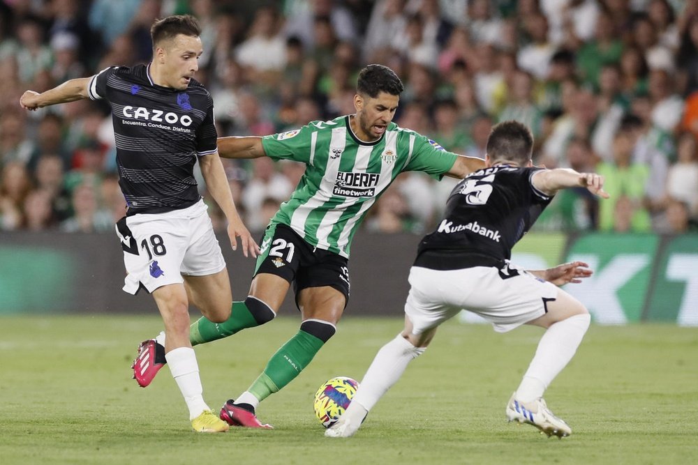 El delantero del Betis, Ayoze Pérez (c), intenta superar a los jugadores de la Real Sociedad, Andoni Gorosabel (i) e Igor Zubeldia, durante el encuentro correspondiente a la jornada 31 de primera división. EFE/José Manuel Vidal.