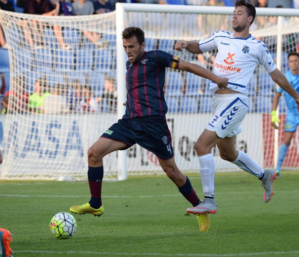 El futbolista del Huesca Carlos David, pugna por un balón con un jugador del Tenerife. Twitter