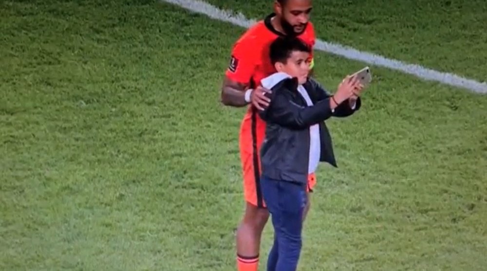 O bonito gesto de Memphis com um menino no meio do jogo. Captura/DAZN