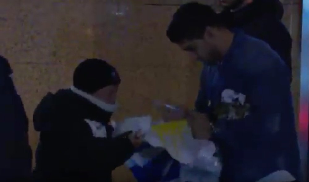 Luis Suarez en train de signer le drapeau Uruguayen d'un jeune supporter. Youtube