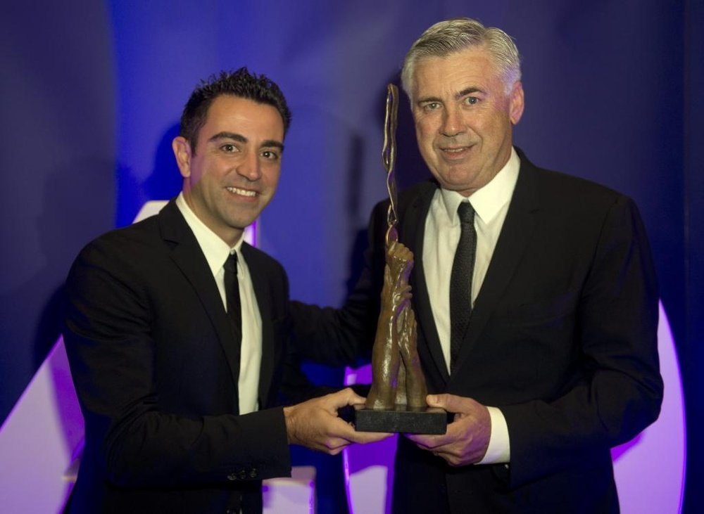 Xavi Hernández (i), hace entrega del premio al liderazgo a Carlo Ancelotti. Twitter