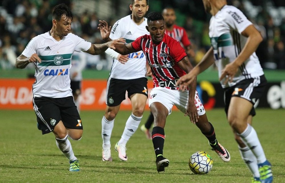 El jugador del Sao Paulo Thiago Mendes trata de zafarse de la presión de tres rivales del Coritiba en el encuentro que les enfrentó y que acabó con empate a un gol. SaoPauloFC