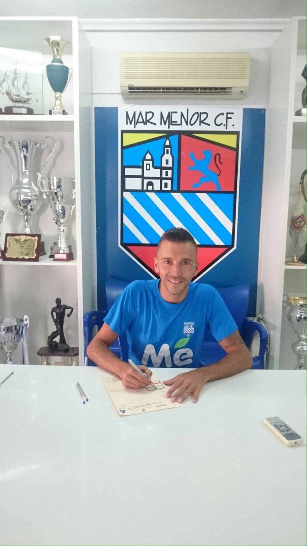 El nuevo futbolista del Mar Menor Txiki, en el momento de firmar su nuevo contrato. Twitter/MarMenorCF