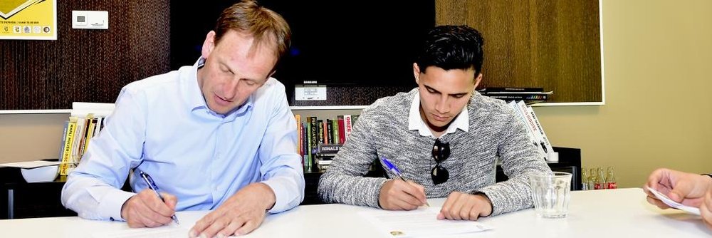 El nuevo futbolista del Vitesse Navarone Foor (d), en el momento de estampar su firma en el contrato que le vincula al club holandés. Vitesse