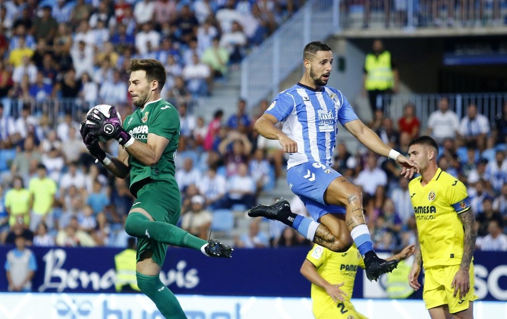 El portero Gianni Cassaro atrapa un balón ante Fran Sol en el Málaga CF 1-1 Villarreal B de la Segunda División 2022-23. Marilú Báez