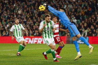 El portero portugués del Real Betis, Rui Silva, despeja un balón ante su compañero Germán Pezzella, durante el partido ante el Granada. EFE/JulioMuñoz