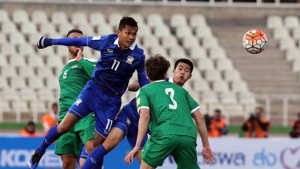 Tossakrai (i) cabecea el balón ante Ismail (c), en el Irak-Tailandia jugado en Tehran. AFP