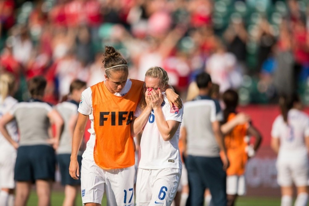 England Jo Potter (L) consoles teammate Laura Bassett after she scored an own-goal in the last minutes of the game giving Japan the win in their semifinal match at the FIFA Women World Cup in Edmonton, Canada on July 1, 2015