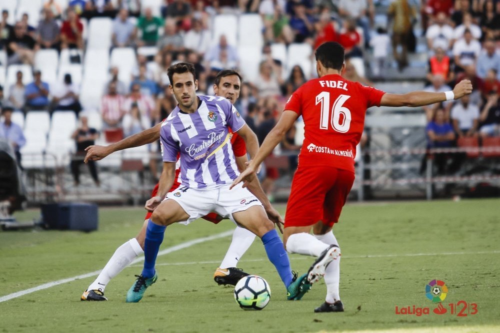 Fidel intenta despejar un balón ante la mirada de Kiko Olivas en el Almería-Real Valladolid. LaLiga