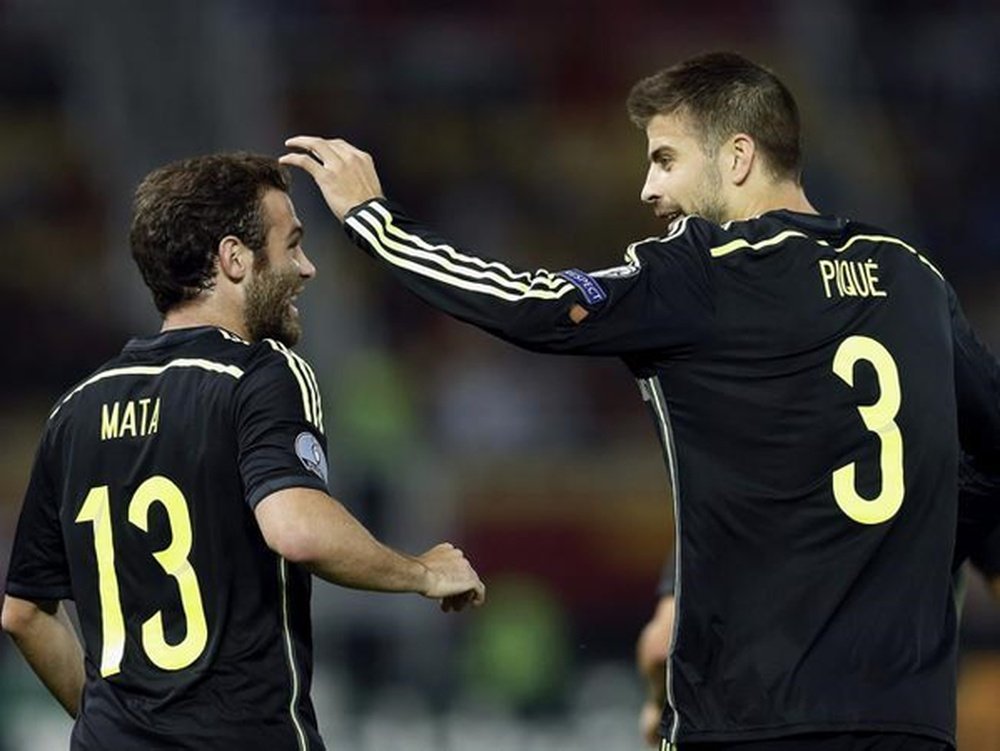 Gerard Piqué (d) felicita a Juan Mata por su tanto a Macedonia. Twitter