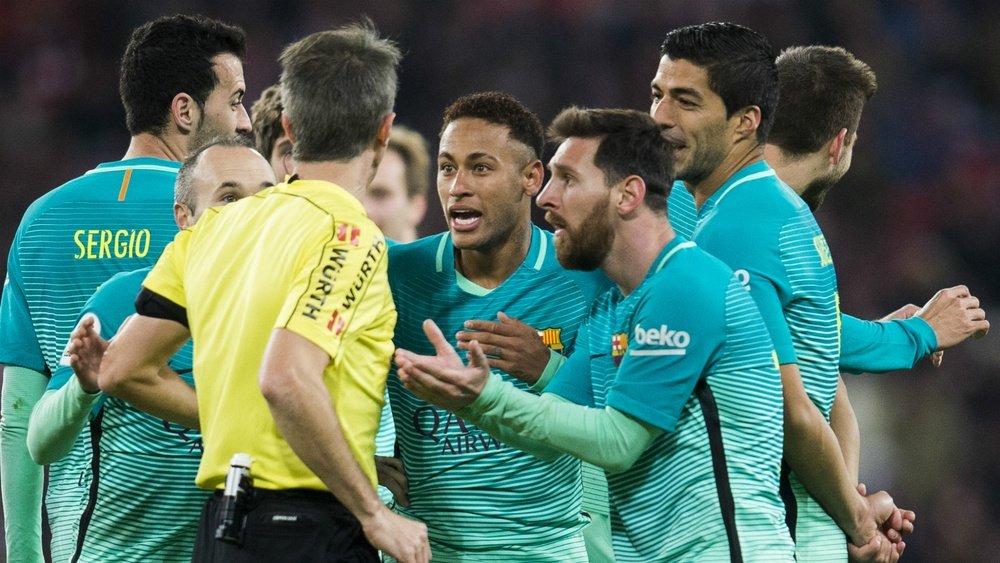 Barcelona players complaining to a referee. Goal