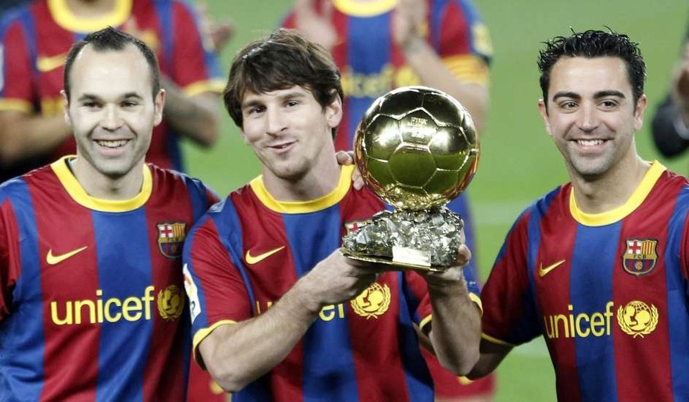 Iniesta, Messi y Xavi enseñan el Balón de Oro al Camp Nou. EFE
