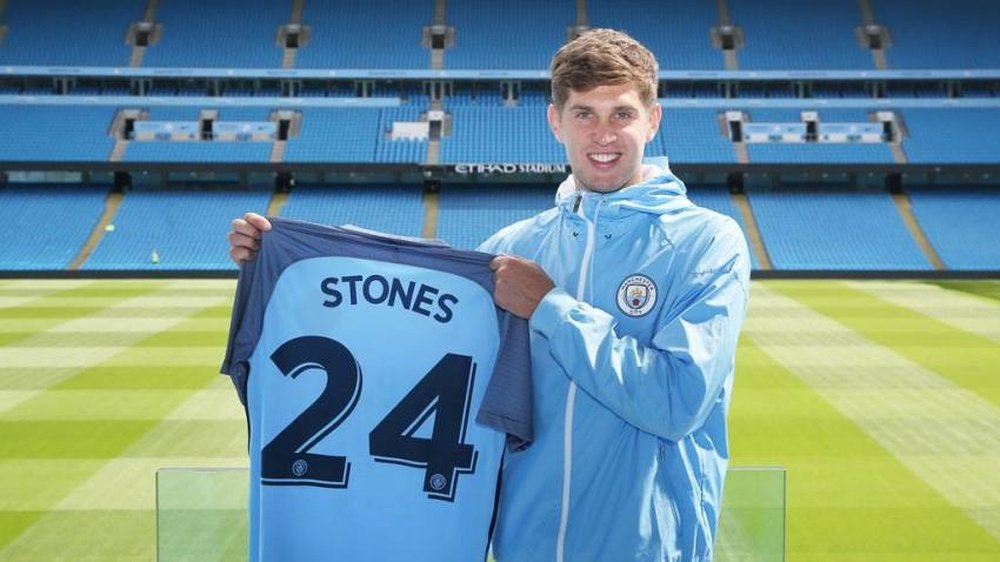 Stones poses with the Manchester City shirt. ManCity