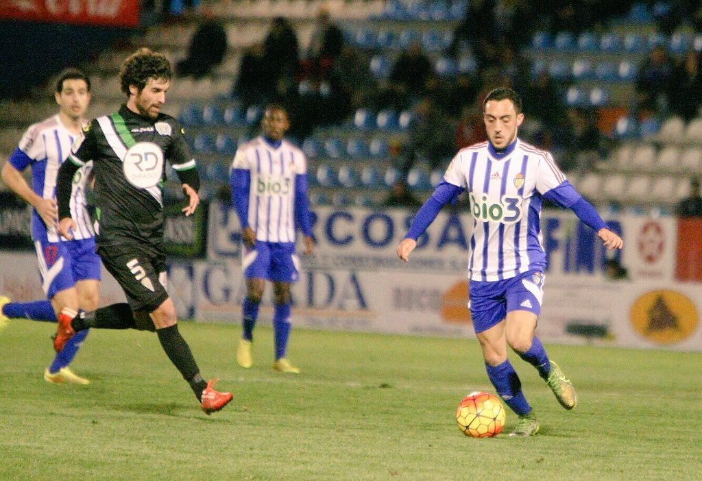 Jugador de la Ponferradina conduciendo el balón ante otro del Córdoba. Twitter