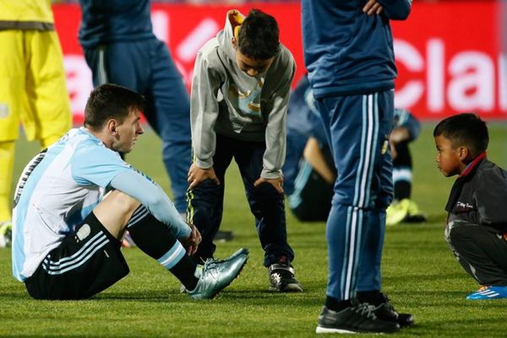 Leo Messi, triste tras perder la final de la Copa América contra Chile, siendo consolado por dos hinchas chilenos. @plisotto. 