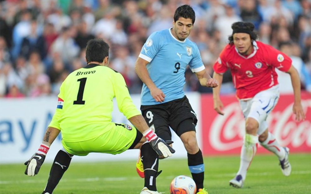 Luis Suárez, delantero de Uruguay, encara a Claudio Bravo, portero de Chile, el día que le marcó 4 goles. AFP