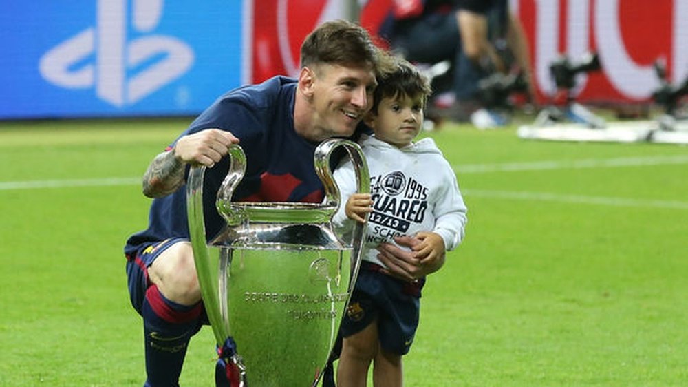 Messi and Thiago posing with the Champions League trophy. Twitter