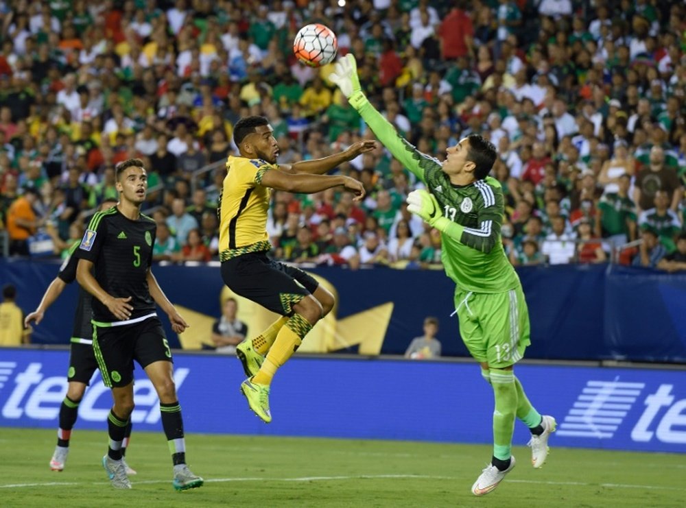 Mexico goalkeeper Guillermo Ochoa (R) knocks the ball away from Jamaica Adrian Mariappa during the 2015 CONCACAF Gold Cup final in Philadelphia on July 26, 2015