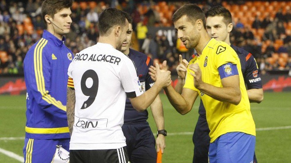 Paco Alcácer y David García, capitanes de Valencia y Las Palmas, se saludan antes del inicio del partido. Twitter