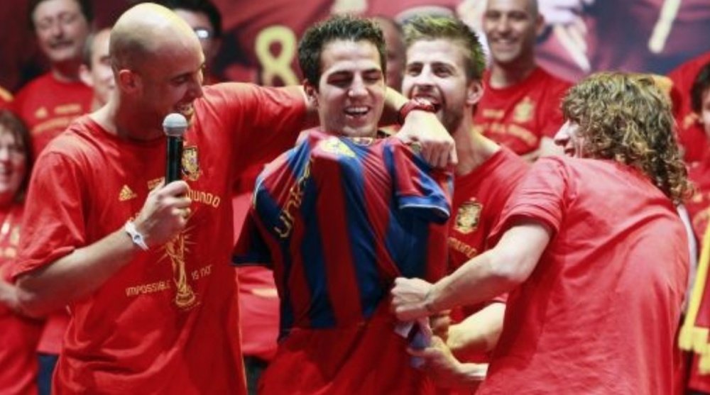 Reina, Puyol y Piqué le ponen una camiseta del Barcelona a Cesc en la celebración del Mundial. EFE