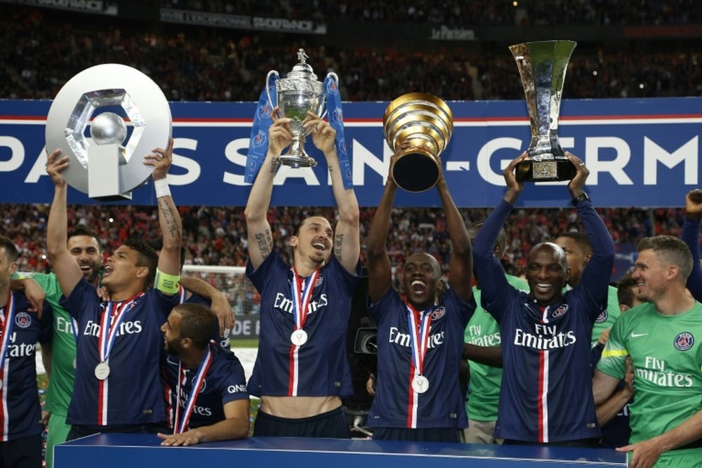 PSG Thiago Silva holding up the Ligue 1 trophy, Zlatan Ibrahimovic holding up the French Cup trophy, Blaise Matuidi holding the French League Cup and Zoumana Camara holding the Champions Trophy celebrate on May 30, 2015 in Saint-Denis